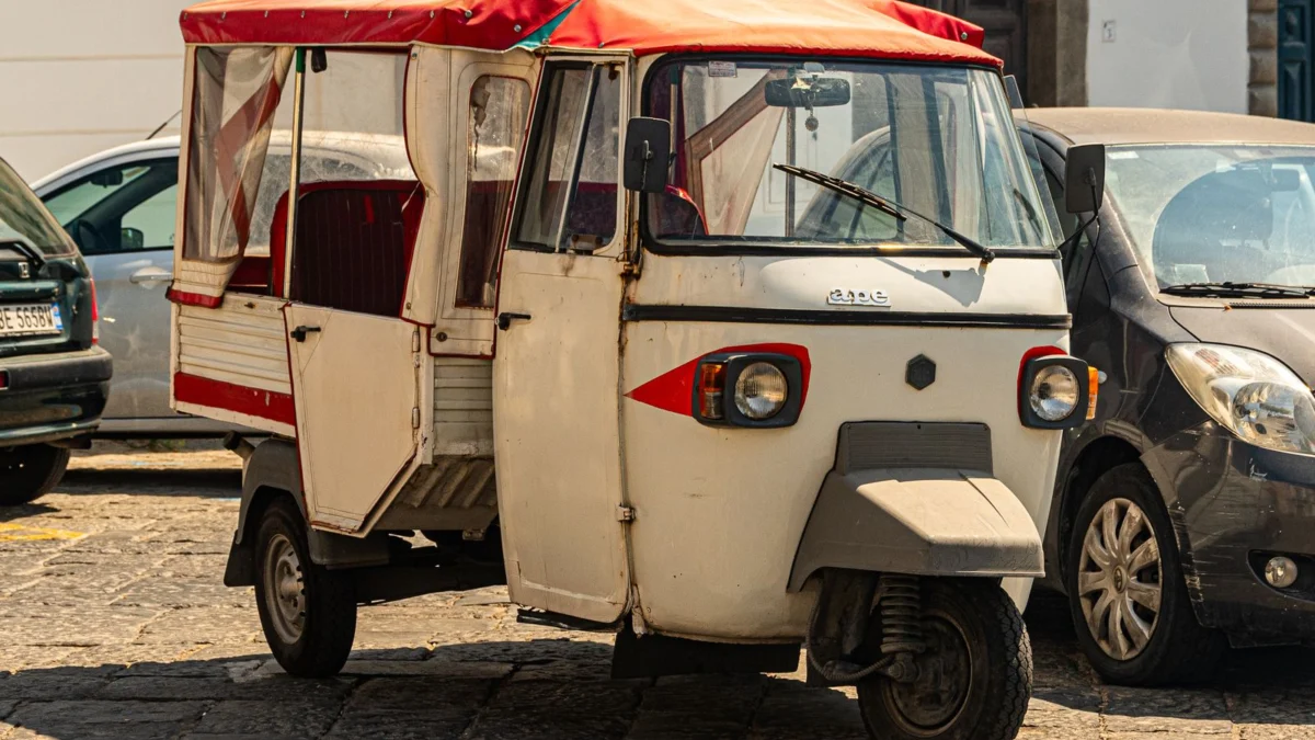 Ape Piaggio d’epoca parcheggiata in una strada assolata della Campania